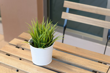 Small artificial trees or Artificial Grass in vase on table with copy space