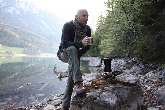 Mann trink ein Kaffee beim Camping
