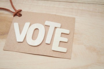 Wooden lettering that says "VOTE" on card paper.