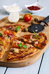 Slices of pizza with bacon, olives and tomatoes