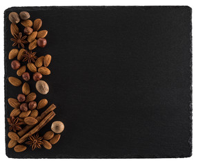 Nuts mix on a black slate board. Isolated on white background.