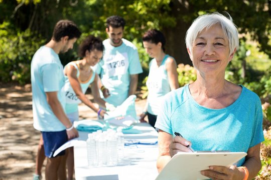 Coach smiling while athletes registering for marathon