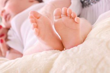 Obraz na płótnie Canvas Little baby sleeping sweetly on the bed and his little feet beautiful look together