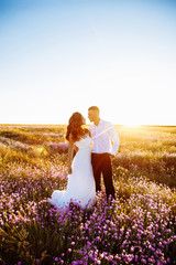 Beautiful couple in field, Lovers or newlywed posing on sunset with perfect sky