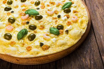 Italian seafood pizza at wood background