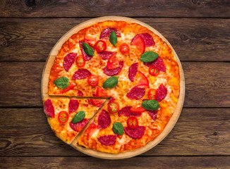 Delicious pizza with salami, top view on wood