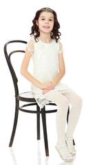 Fototapeta premium Slender little dancer posing near the old Vienna chair.