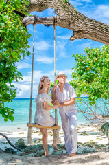 Couple of lovers on a swing. Maldives island