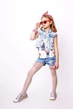 Cute little girl with red lips posing in studio.