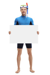 Young man with snorkeling equipment holding a blank signboard