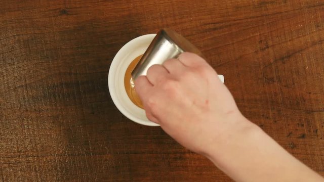 Barista pours caramel syrup in a cup