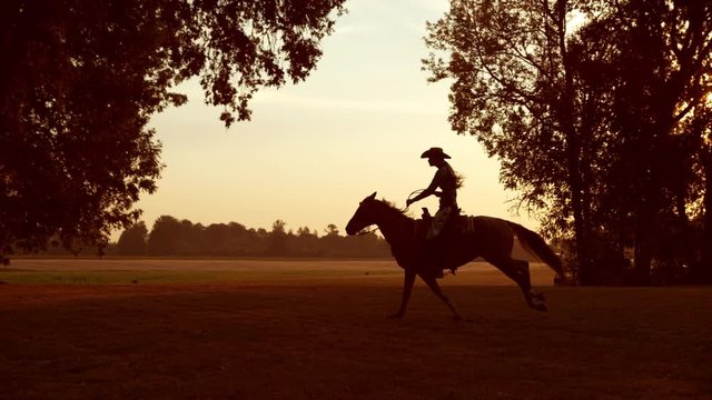 Woman horseback riding at sunrise in super slow motion
