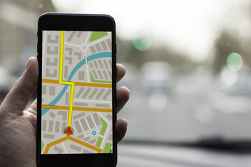 GPS Navigation on Mobile Phone Device and Transportation Concept. Male Hand Using Navigation System...