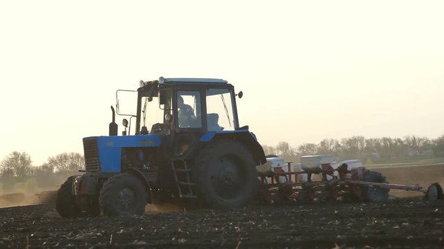 Tractor Processing Field Farmer sowing a plowed field with old tractor