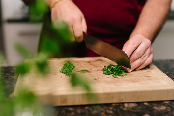 Cutting chive on wooden plate