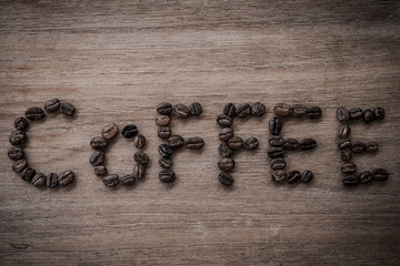coffee beans isolated on wood background.