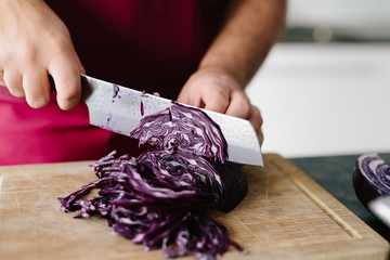 Man is cutting red cabbage