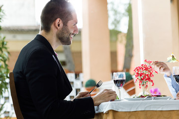 Handsome young man eating salad in the restaurant.