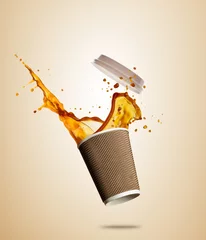 Rolgordijnen Cup with splashing coffee or tea liquid separated on brown background. Take away hot drink © Jag_cz