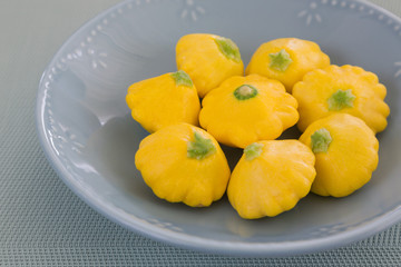Naklejka na ściany i meble Fresh yellow patissons on a gray plate. Miniature food