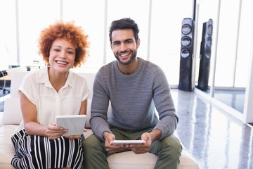 Portrait of smiling business colleagues with tablet pcs