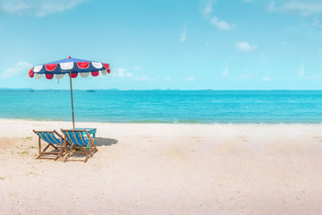 Two canvas beach bed and beach umbrella on the beach with nice sky and cloud at noon time.Holiday concept, relaxation