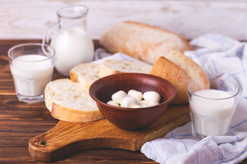 Sliced wheat bread, glass of fresh milk and mozzarella