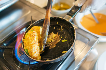 Omelette in a frying pan with cheese, ham, tomatoes, basil, greek cheese, parmesan, olives, toast for breakfast