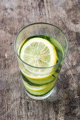 Detox water with cucumber and lemon on wooden table
