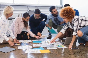 Creative business colleagues discussing over documents