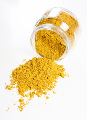 Curry in glass jar. Heap. Isolated on white.