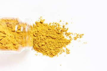 Curry in glass jar. Heap. Isolated on white. Top view.