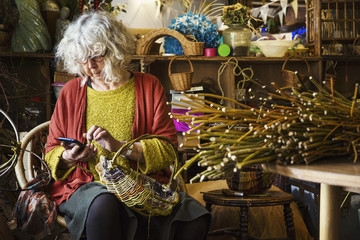 Woman weaving basket in weaver's workshop