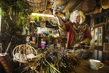 Woman weaving basket in weaver's workshop