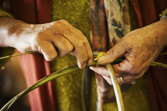 Close up of woman weaving a basket in weaver's workshop.