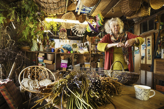 Woman weaving a basket in a weaver's workshop.