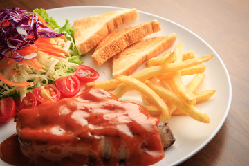 Steak and Spicy sauce on white dish and wooden background