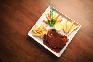 Grilled pork with barbecue sauce and vegetables salad sauce on white dish wooden background