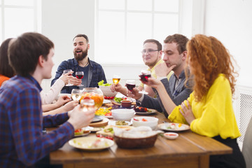 Group of happy people at festive table dinner party