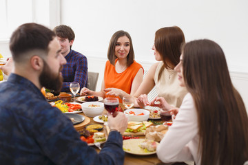 Group of happy people at festive table dinner party