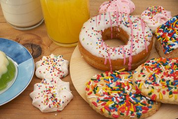 Desayuno con donas, galletas, café, leche y jugo