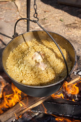 Pilau in cauldron on fire