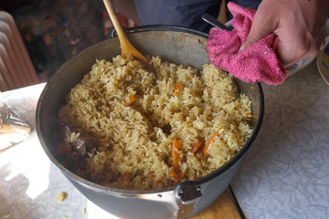 Pilau in cauldron on the table