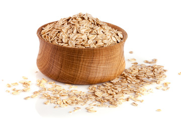 oat flakes in a wooden bowl isolated on white background