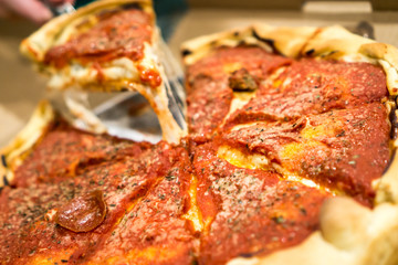 Deep Dish Pizza with a slice being pulled and cheese hanging. Copyright © Paul Velgos with All Rights Reserved.