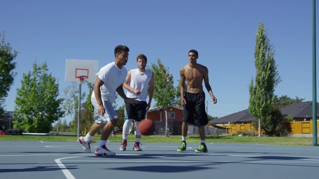 Slow motion shof of friends playing basketball at park