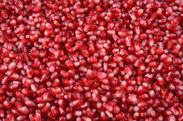 Pomegranate. Fresh raw fruit seeds. Red background.