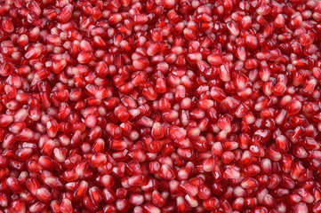 Pomegranate. Fresh raw fruit seeds. Red background.