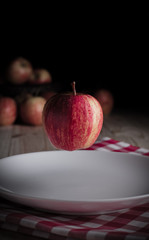 An organic apple on a wooden table and black background