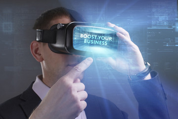 Business, Technology, Internet and network concept. Young businessman working in virtual reality glasses sees the inscription: Boost your business